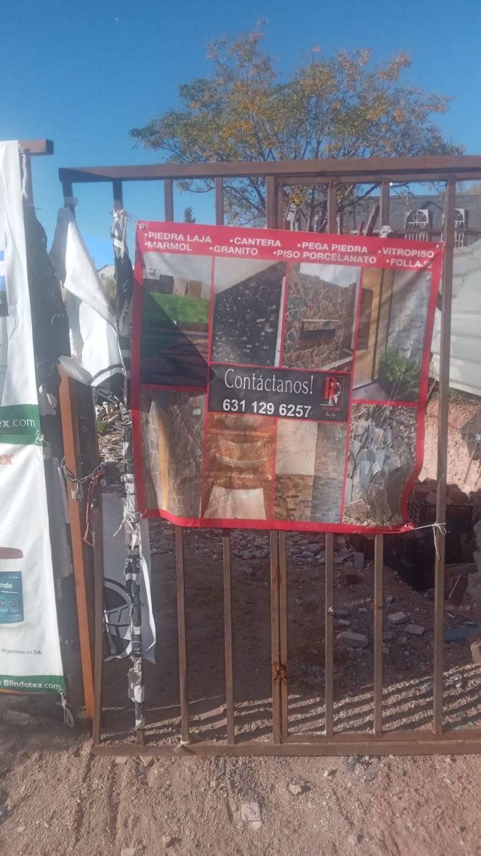 Portón de entrada del patio con la lona roja del negocio